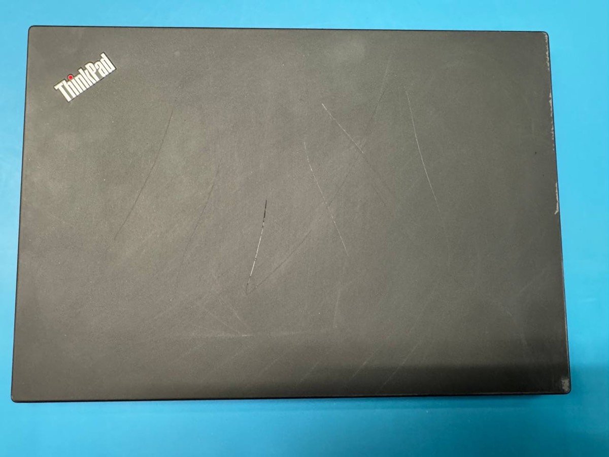 A scratched laptop lid before cosmetic refurbishment