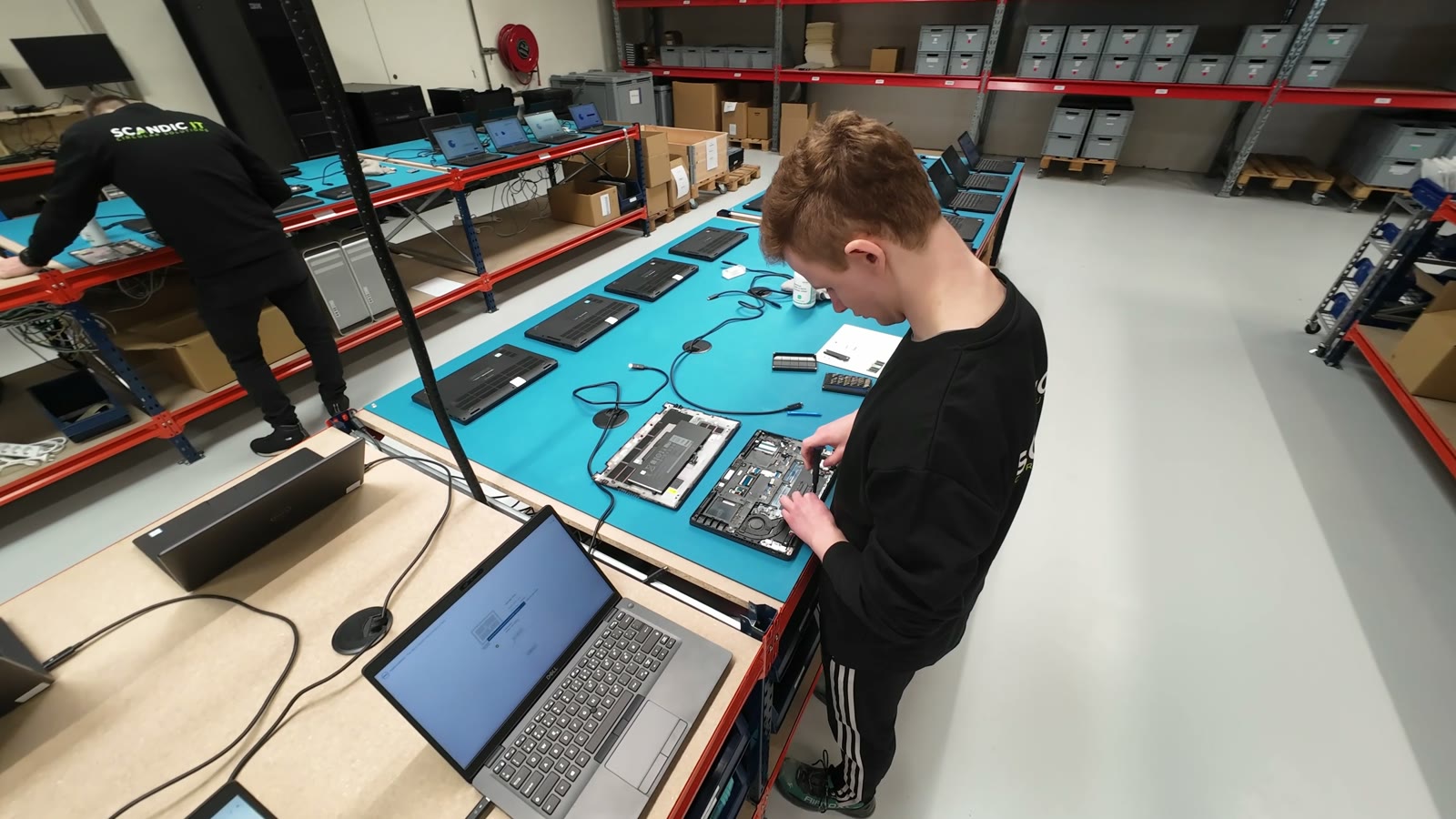 A technician repairing a laptop at the Scandic IT facility